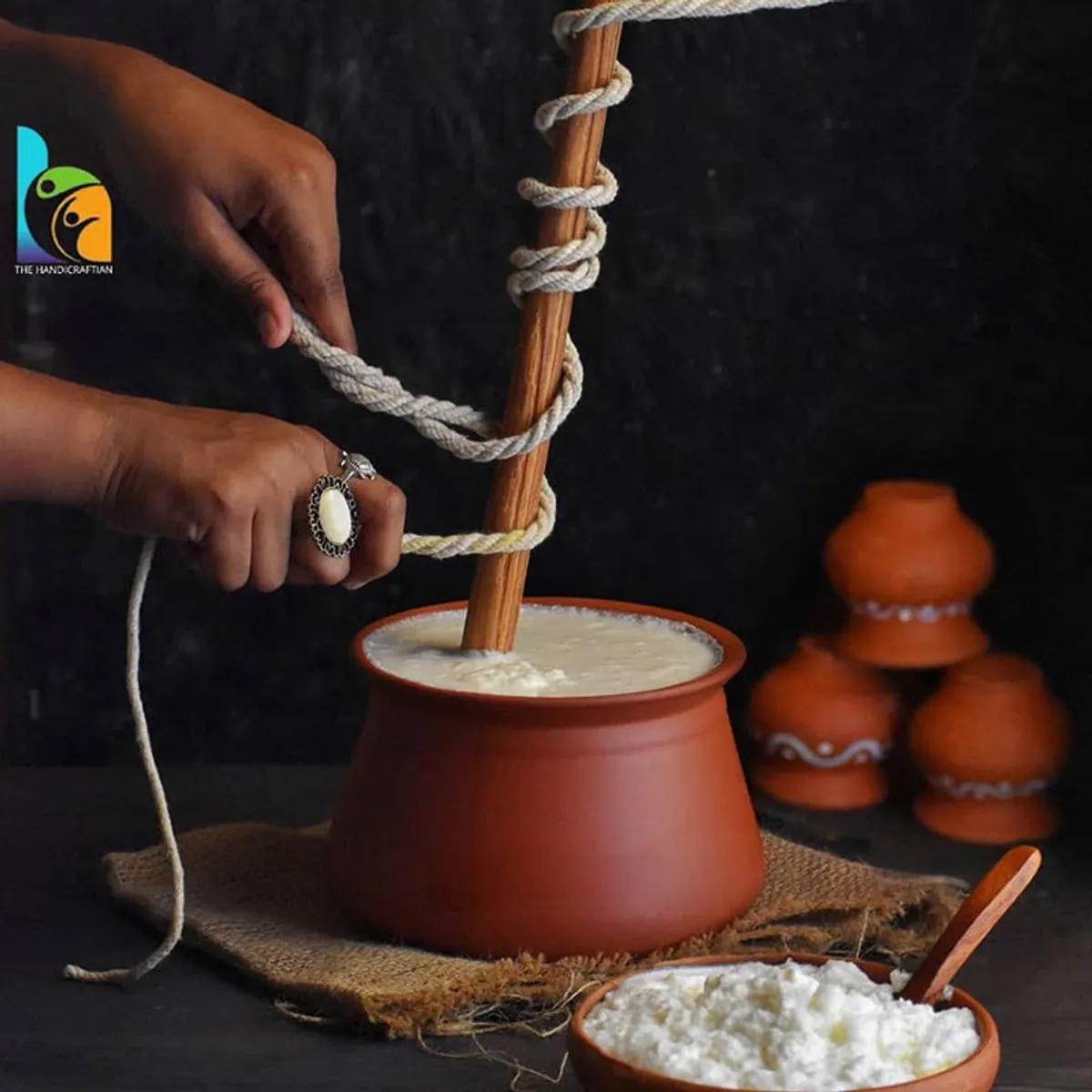 Terracotta handi filled with curd, shown in a rustic food preparation setting
