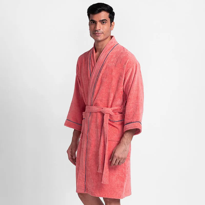 Angled view of a peach bath robe with navy-trimmed edges