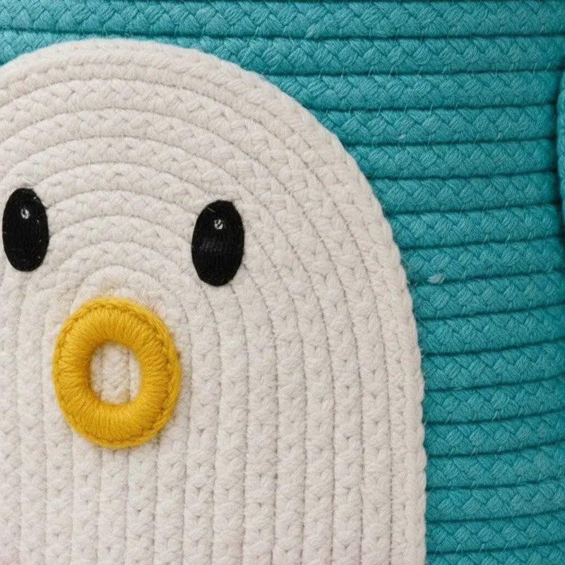 Close-up of the penguin face motif on the blue woven basket