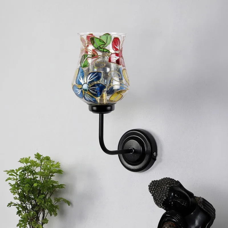 Multicolour floral glass wall lamp with black iron arm mounted on a white wall