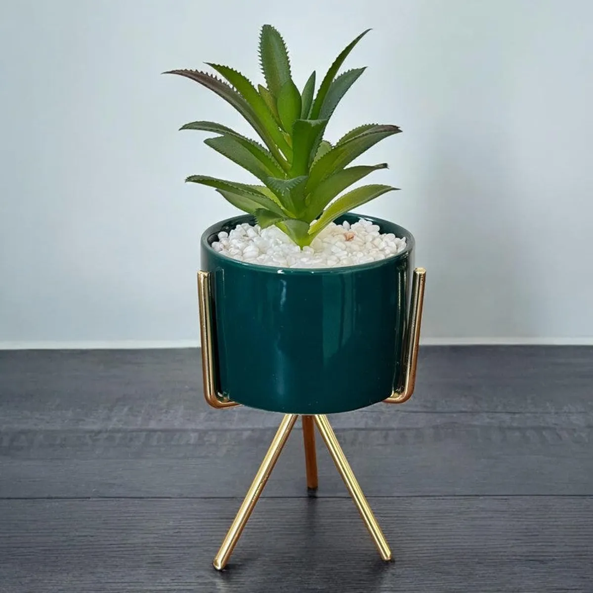 Close-up of green artificial plant in a glossy ceramic planter