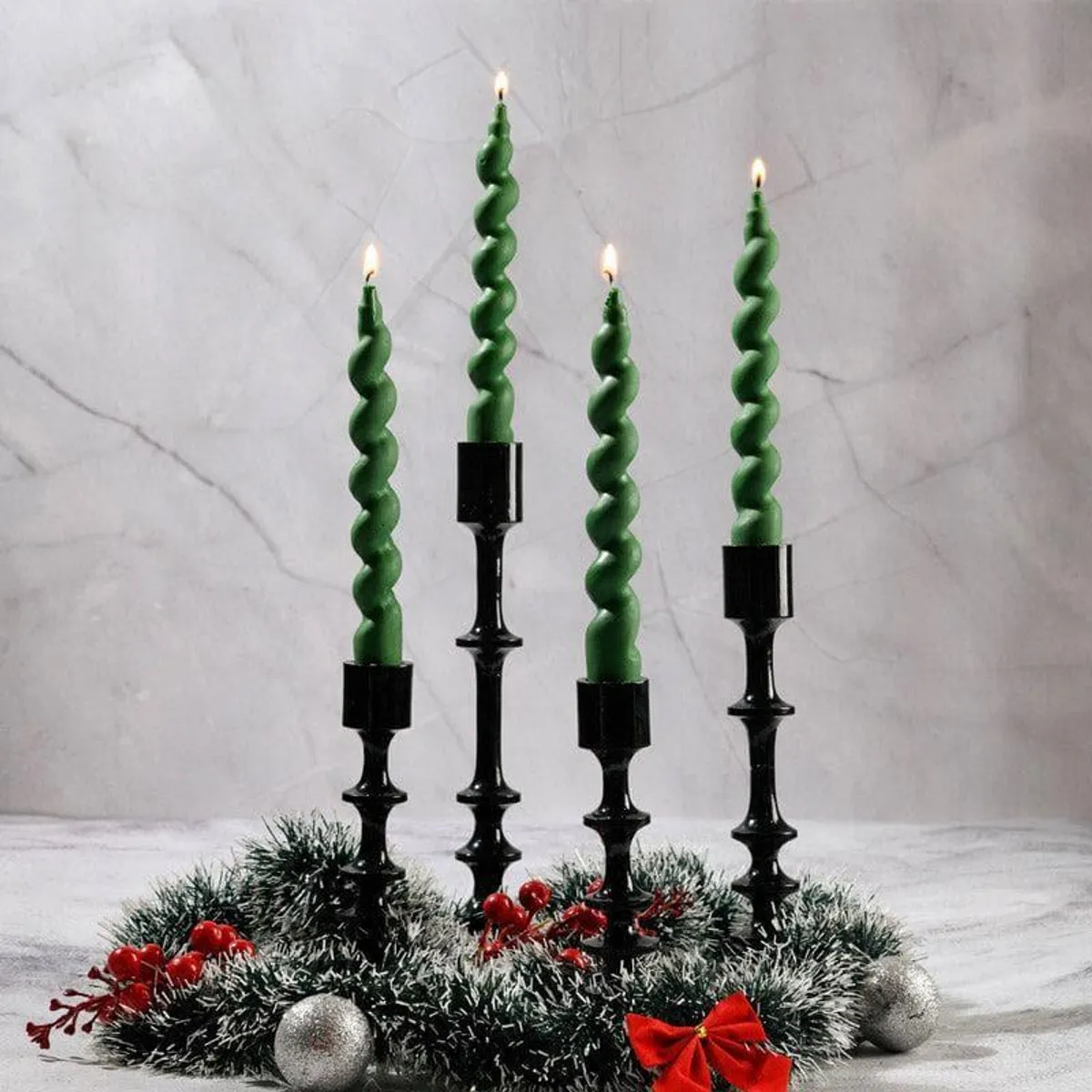 Lit green spiral taper candles arranged with festive decor