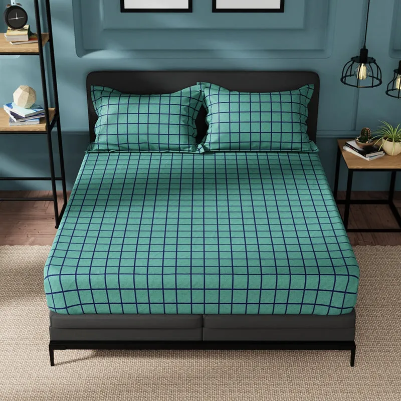 Green geometric grid bedsheet spread across a double bed