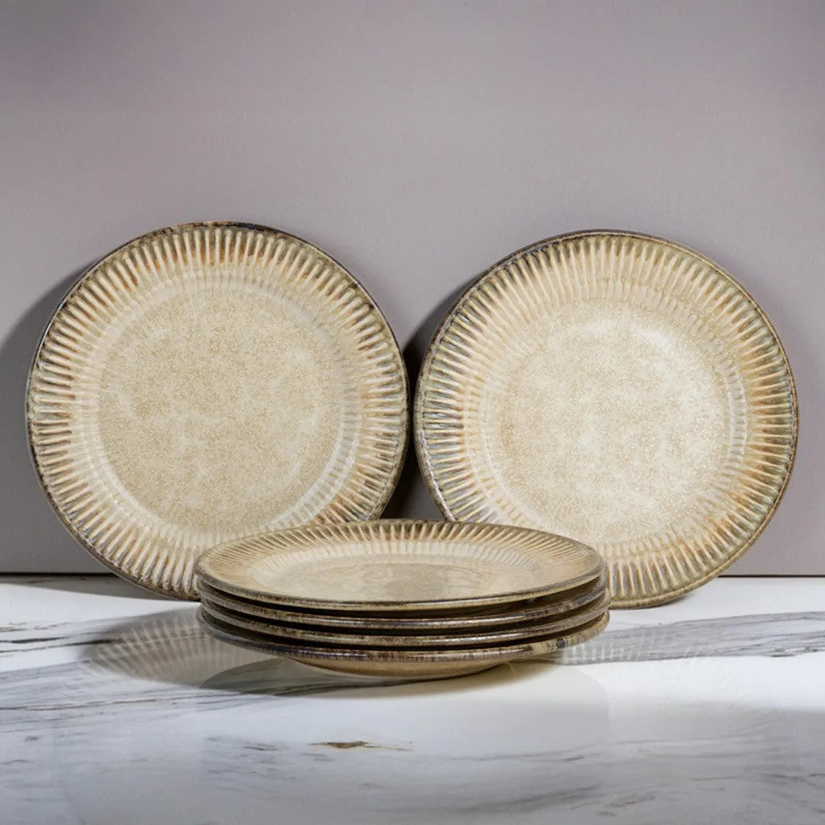 Stacked beige ceramic quarter plates with two plates displayed upright