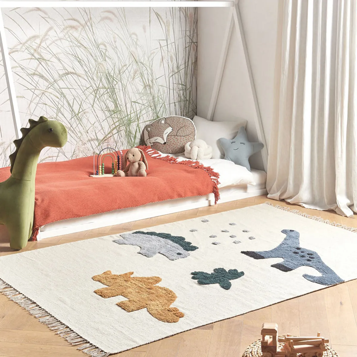 Cream rectangular rug with colourful tufted dinosaur motifs and fringed edges