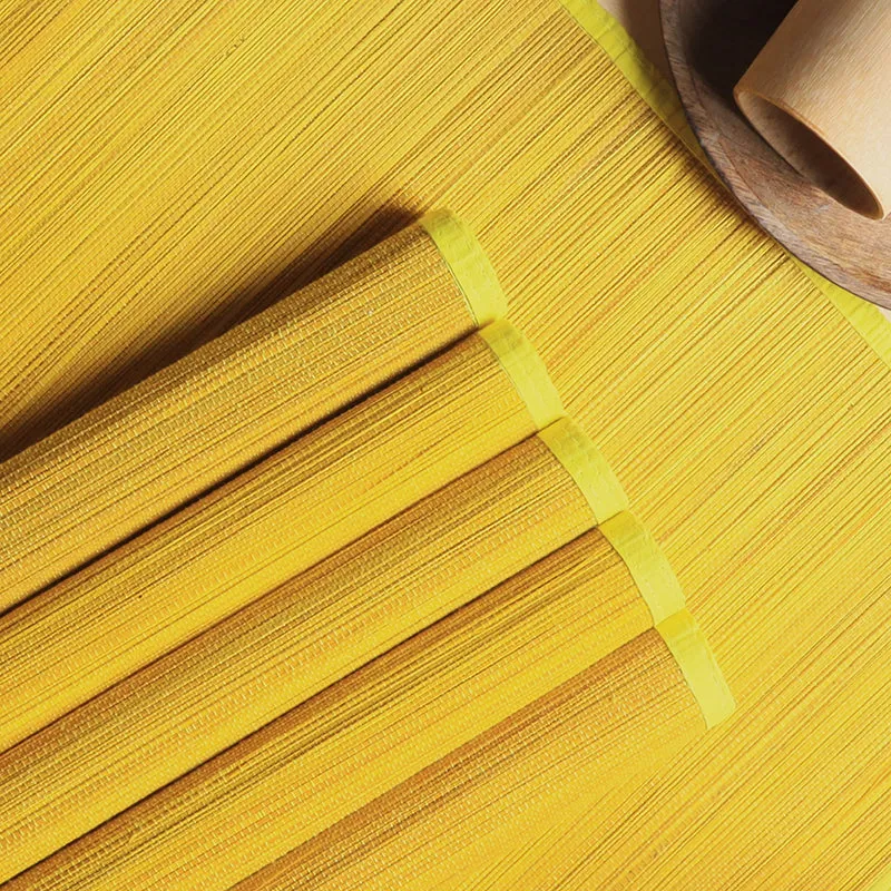 Close-up view of yellow bamboo table mats with a fine linear texture