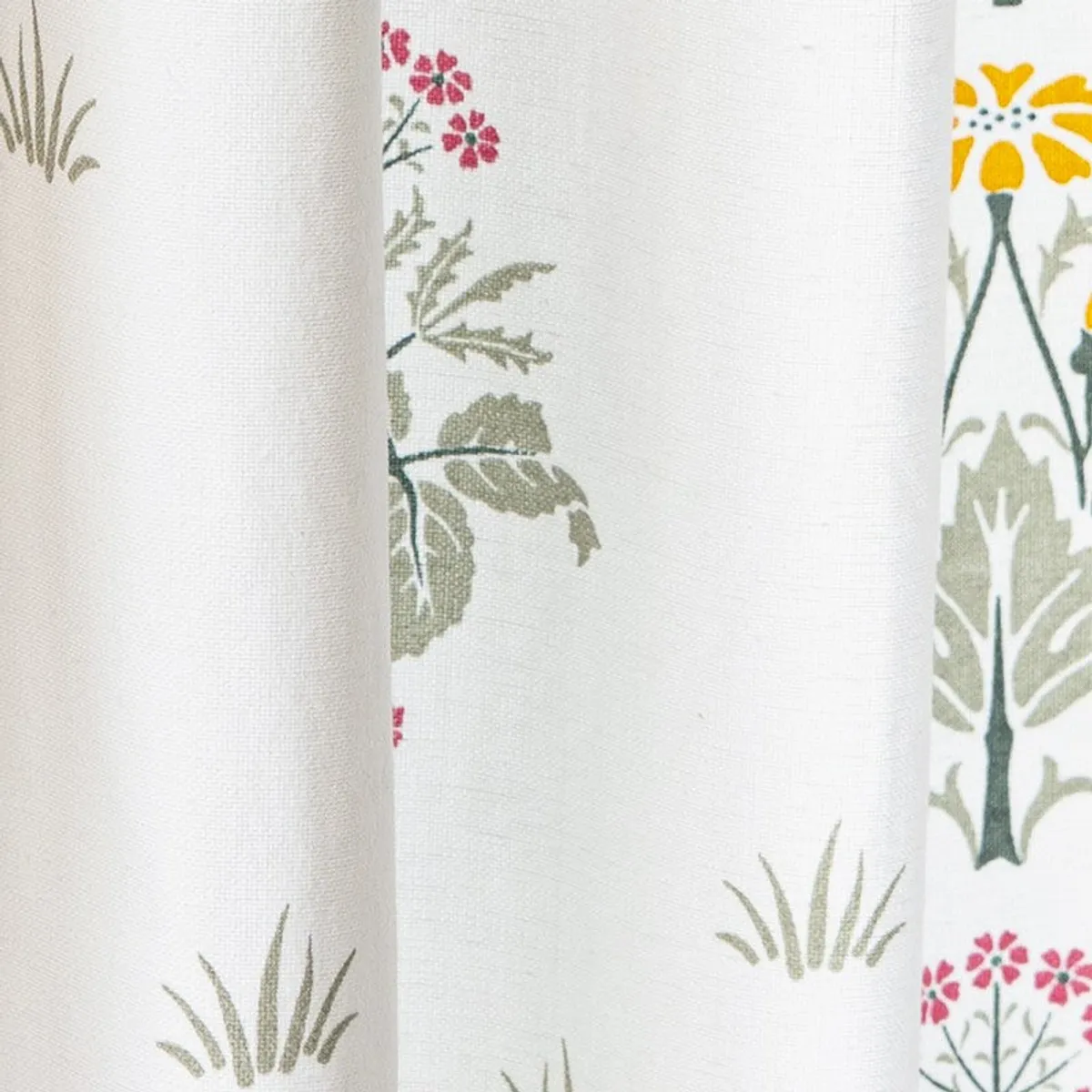 Close-up showing the woven texture of white floral curtain fabric
