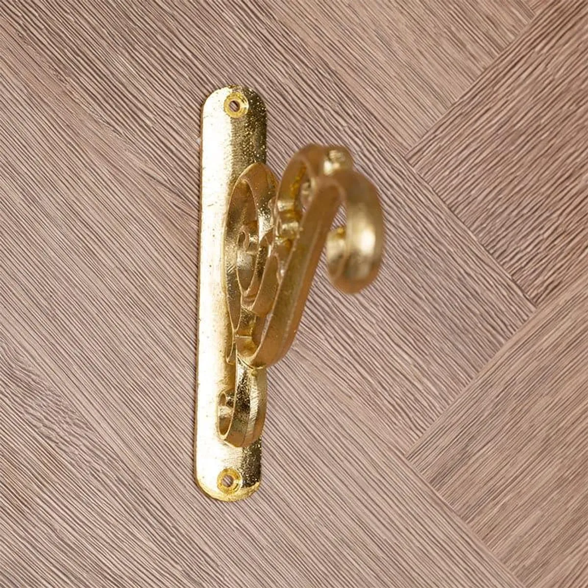 Close side view of the gold metal wall bracket and its wall plate