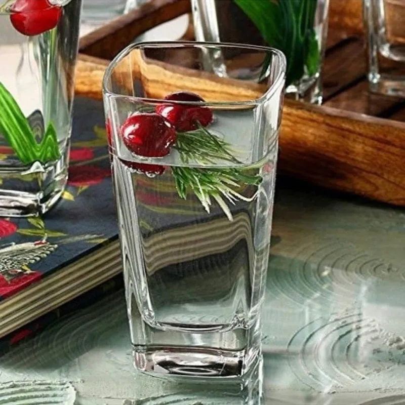 Clear square glass tumbler with a drink and garnish on a tabletop