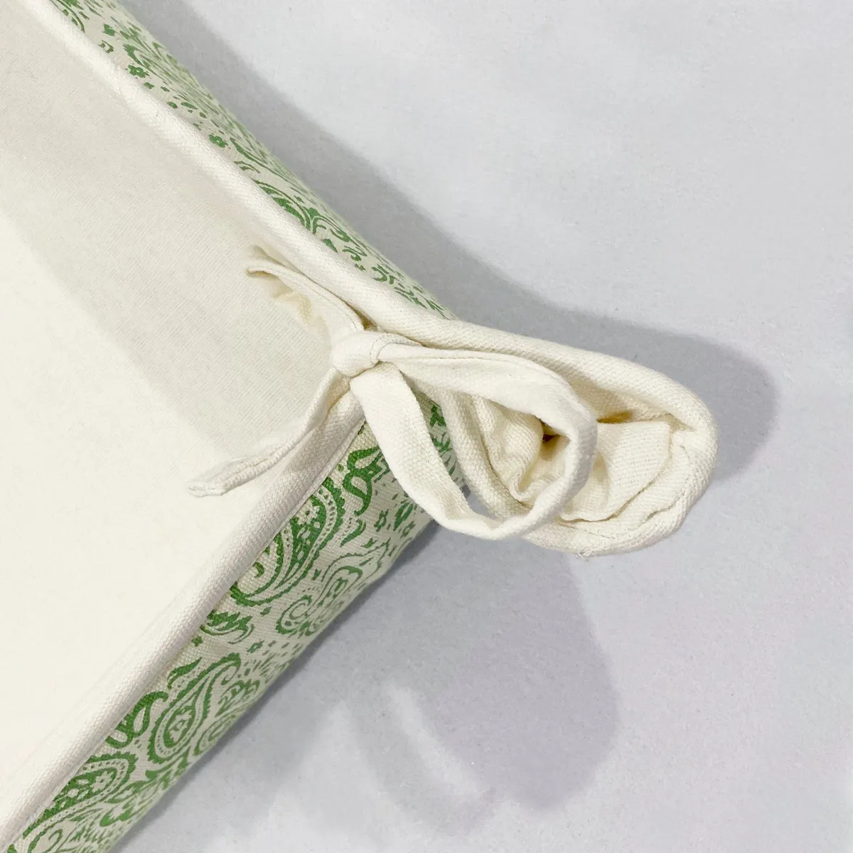 Close-up of tied corner detail on cream and green fabric basket