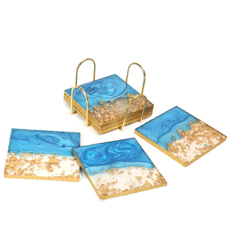 Four blue and gold square coasters with stand on a white background