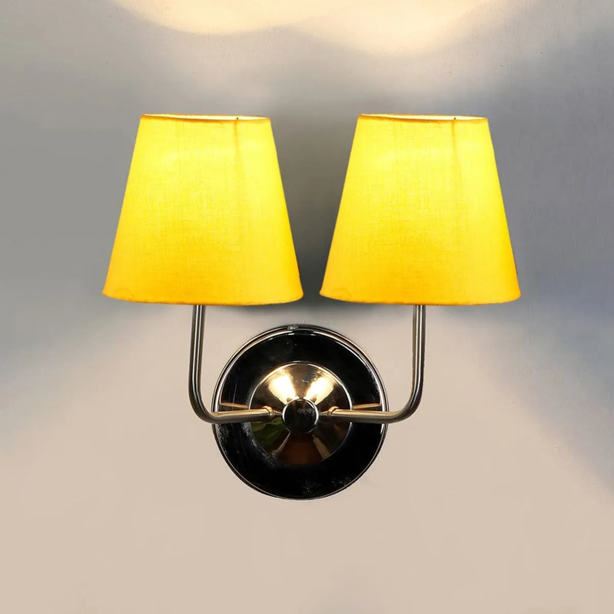 Wall lamp with yellow cotton shade design and steel base on a light wall