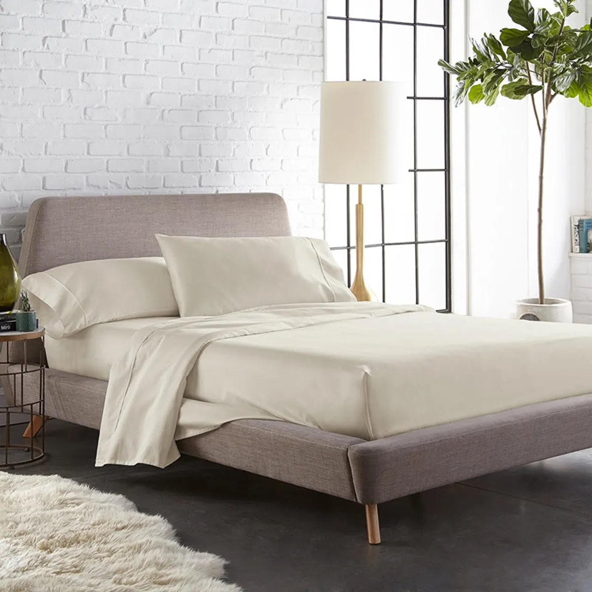 Beige flat bedsheet styled on a modern bed in a bright bedroom