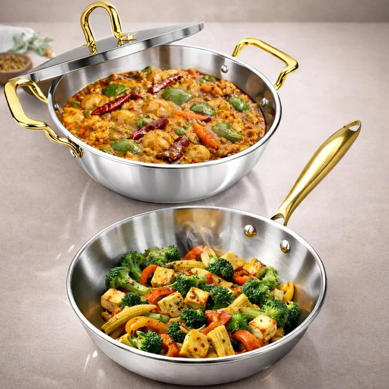 Close view of silver kadhai with lid and frying pan, both with gold handles
