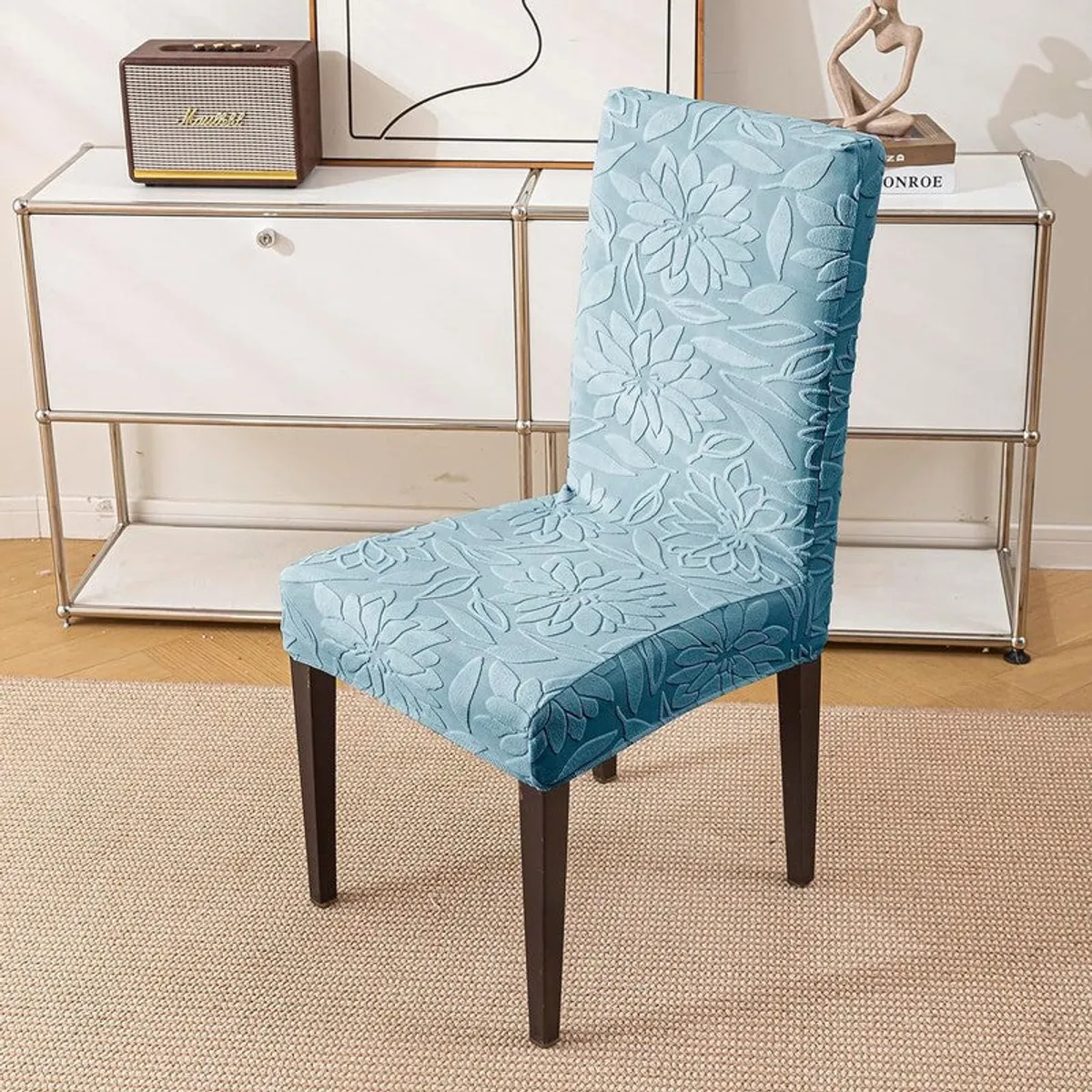 Single light blue floral embossed chair cover fitted on a dining chair