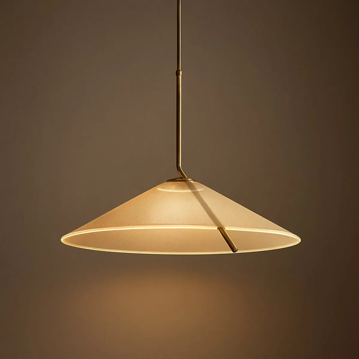 Close-up of a gold-beige conical ceiling lamp with warm downward glow