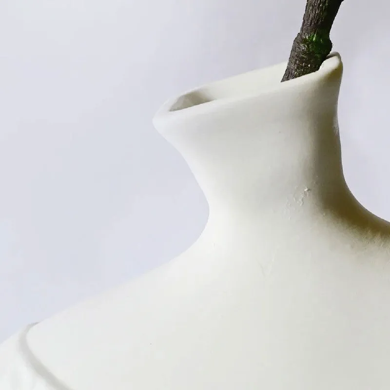Close-up of the narrow neck and smooth upper body of the white vase.