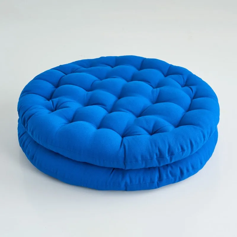 Close-up of a round blue cushion showing its soft, rounded shape.