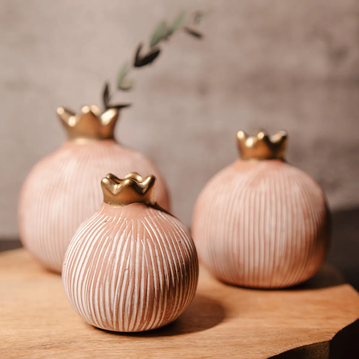 Close view of three textured round vases with gold crown-shaped openings