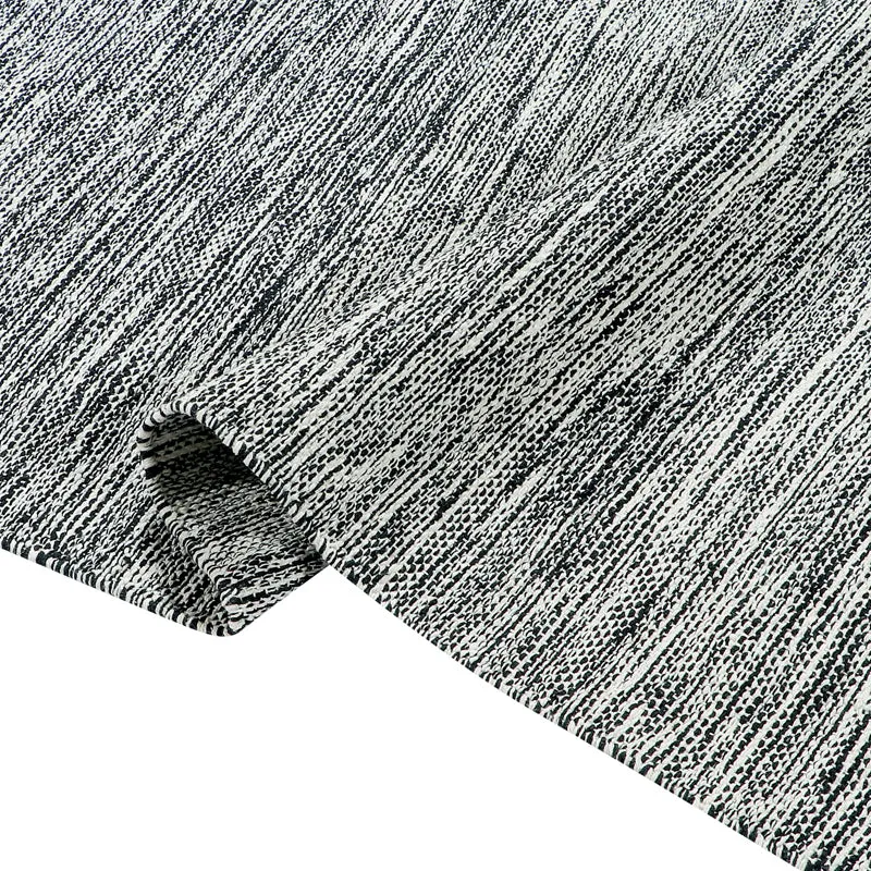 Close-up of the charcoal-grey rug surface with a fine textured linear pattern.