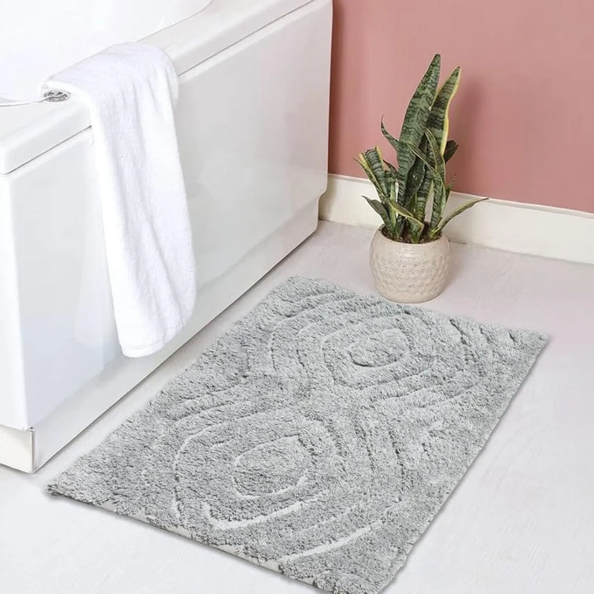 Grey textured bath mat placed beside a bathtub