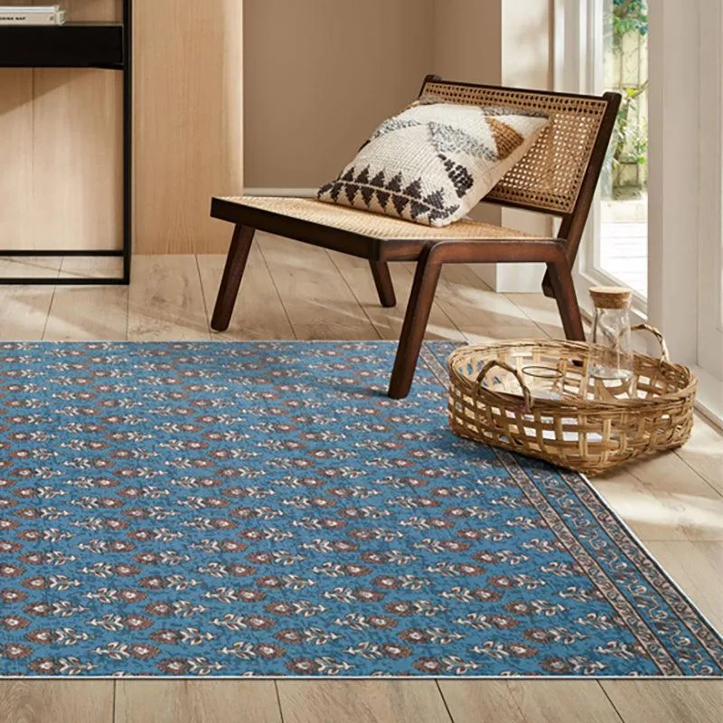 Blue rectangular carpet with ethnic motif placed beside a lounge chair