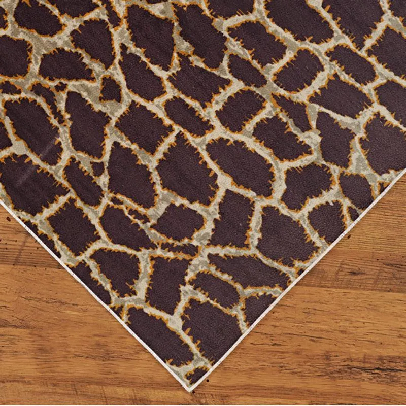 Corner view of the rectangular brown and beige carpet on wooden flooring