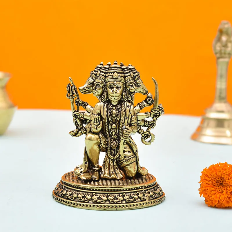 Gold Panchmukhi Hanuman idol displayed against an orange backdrop with marigolds