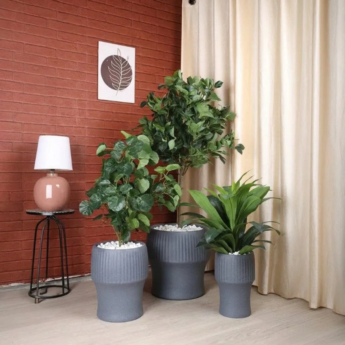Three grey ribbed planters in different sizes displayed with plants