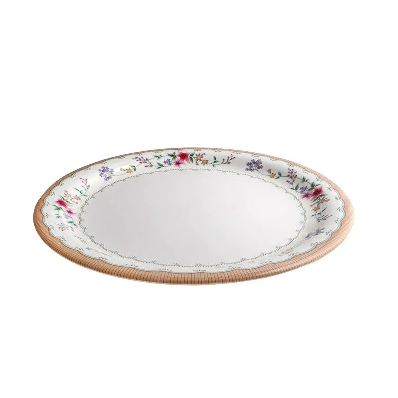 Low side view of a white floral dinner plate with a gently raised rim