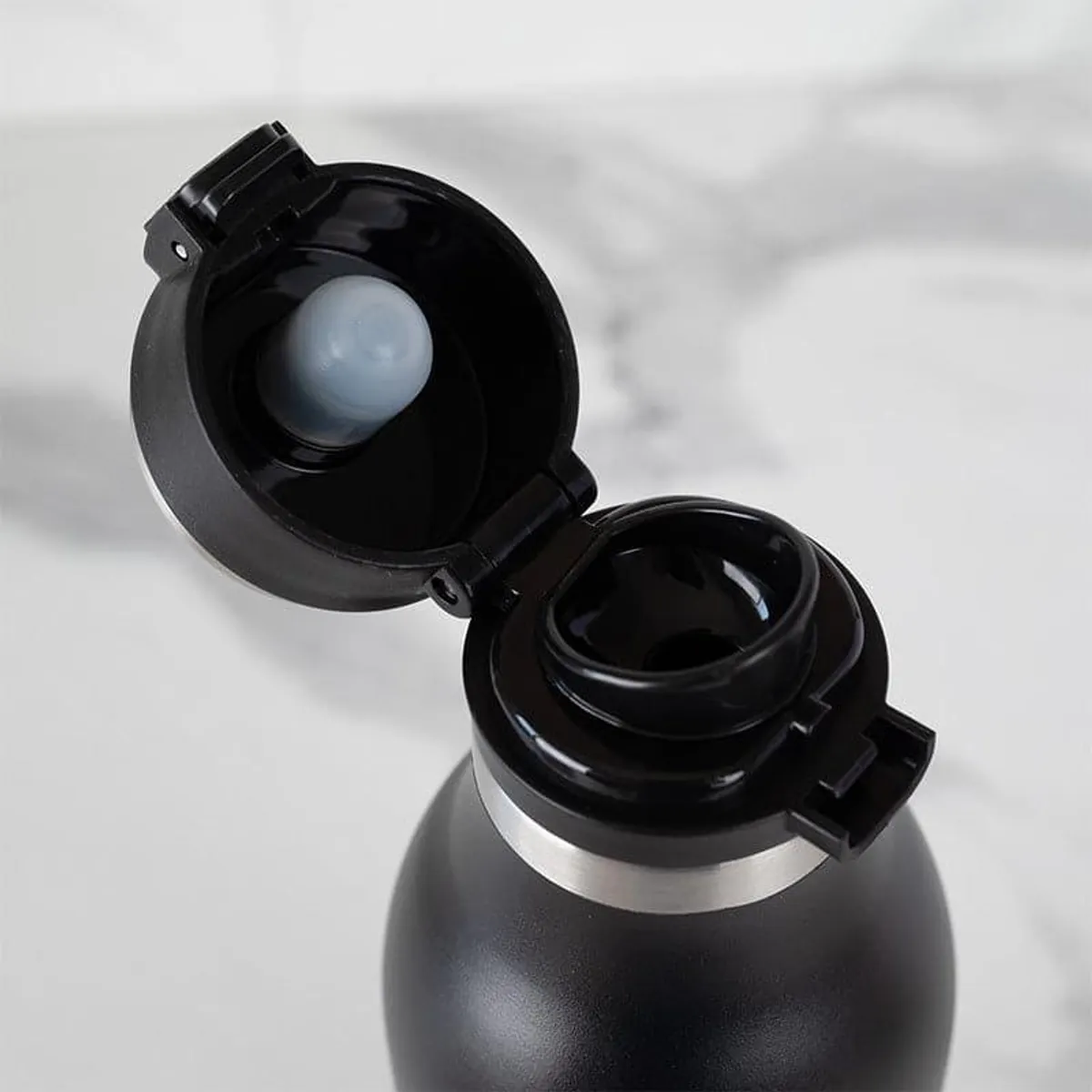 Open black bottle showing the drinking opening and hinged lid