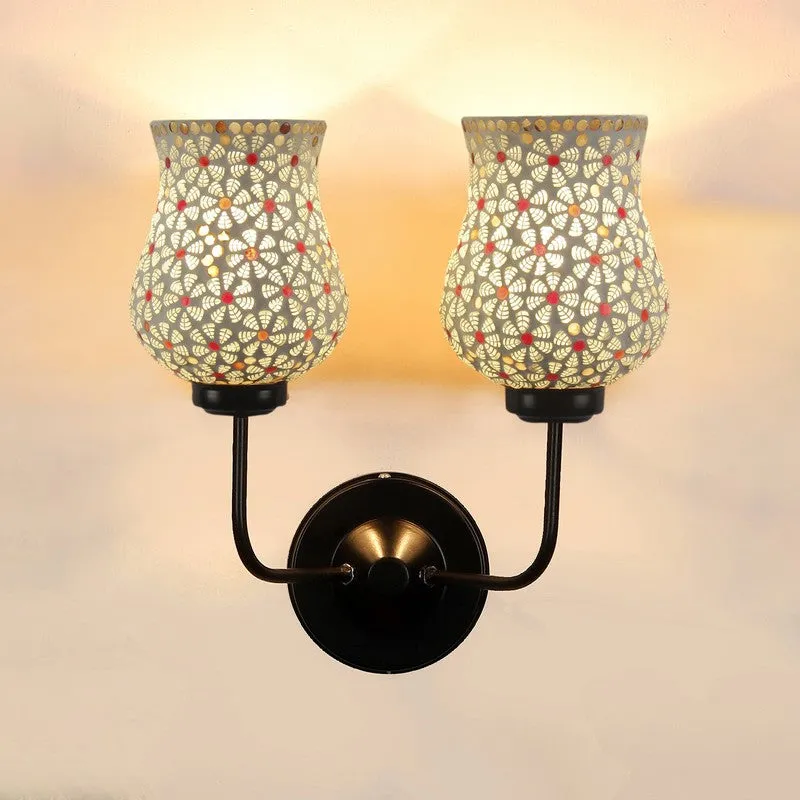 Front view of lit twin ivory mosaic glass wall lamp with black wall plate