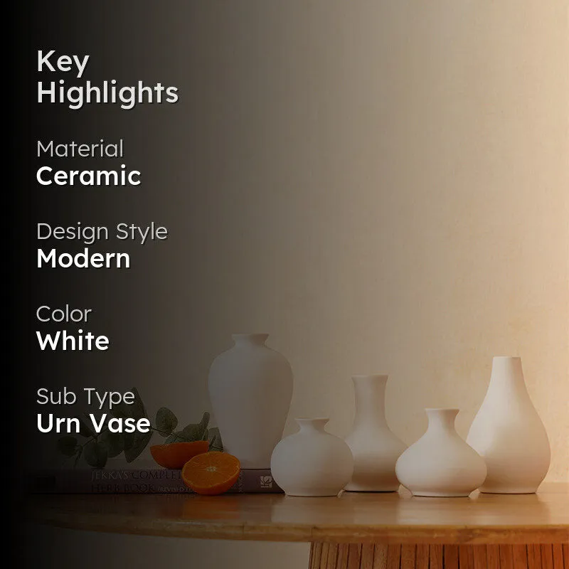White vase set styled on a wooden table against a warm neutral wall