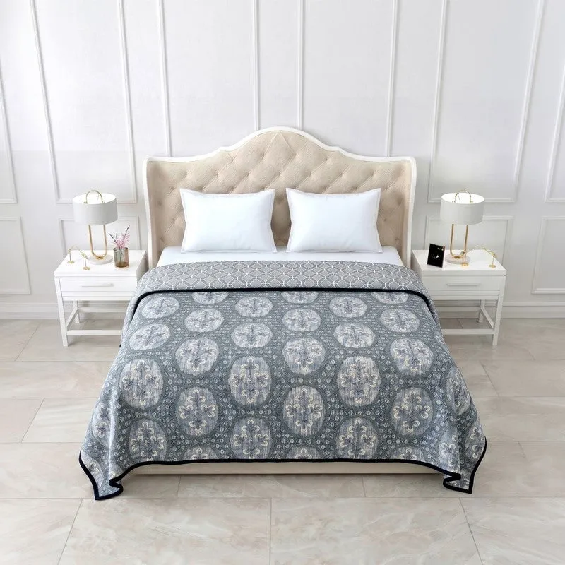 Blue reversible dohar spread on a bed with ethnic medallion print