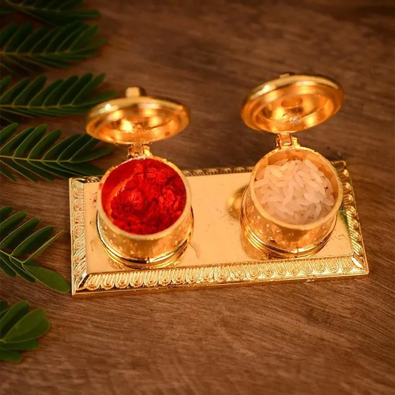 Top view of a gold tray with open containers holding red roli and white rice