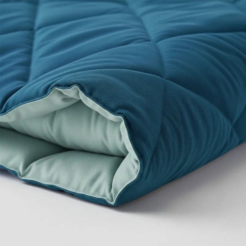 Close-up of the quilted comforter showing its blue and pale teal reversible layers