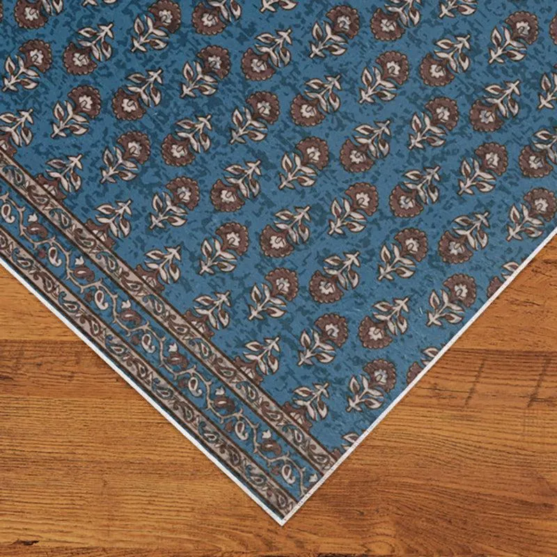 Close-up of blue carpet corner with floral ethnic pattern and border