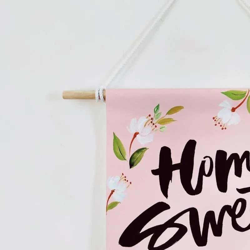 Close-up of pink wall hanging with floral detail and hanging cord