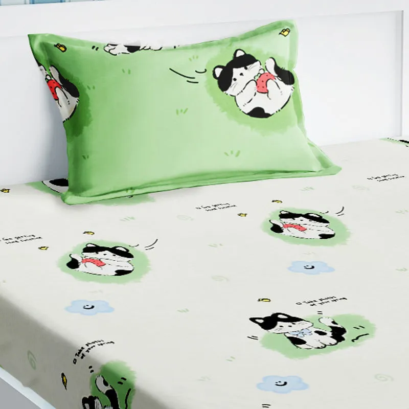 Close-up of green cat-print pillow cover and white printed bedsheet