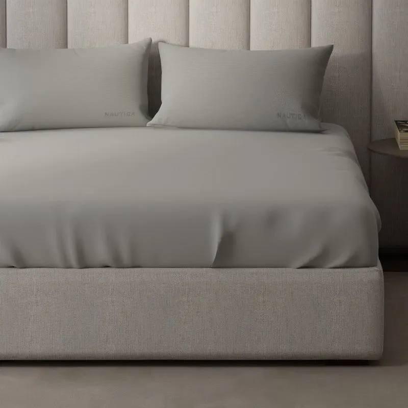Close view of silver-grey solid bedsheet draped over a king bed
