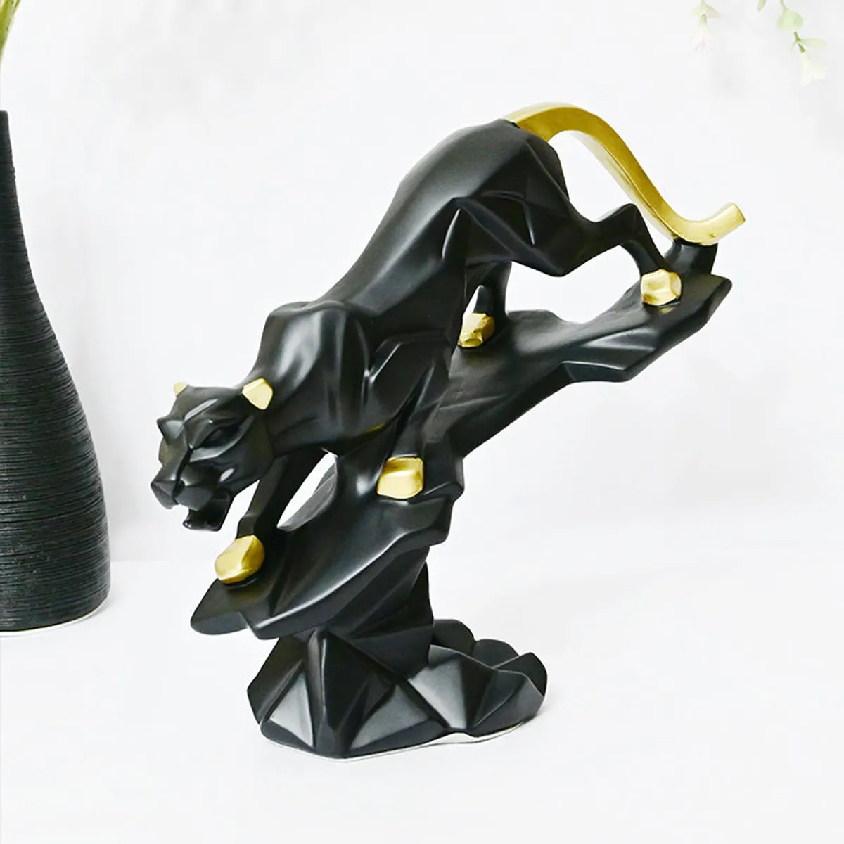 Black and gold panther showpiece styled beside a vase on a tabletop