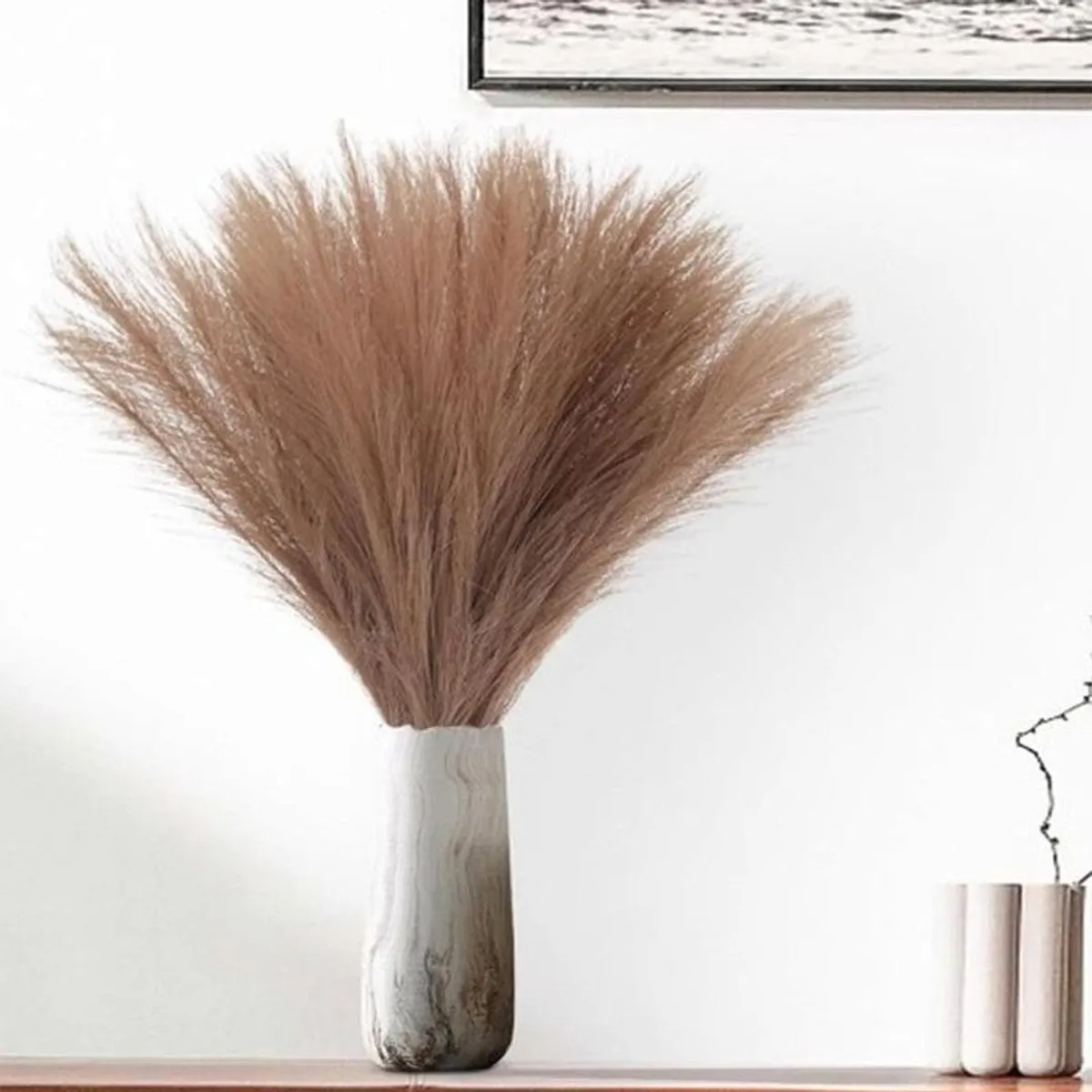 Brown feathery pampas grass arranged in a white vase
