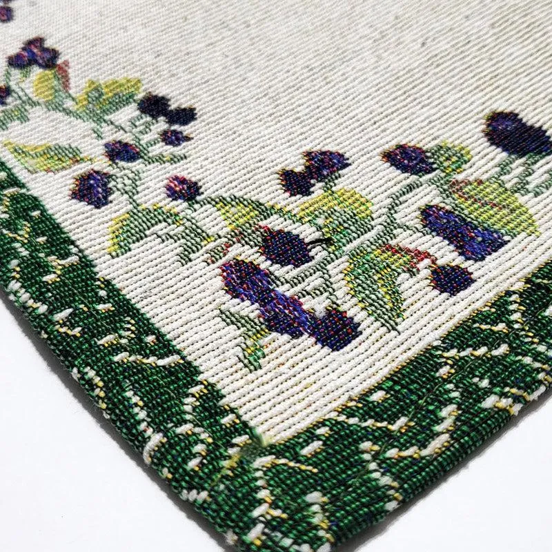 Close-up of placemat corner with green border and floral vine detail