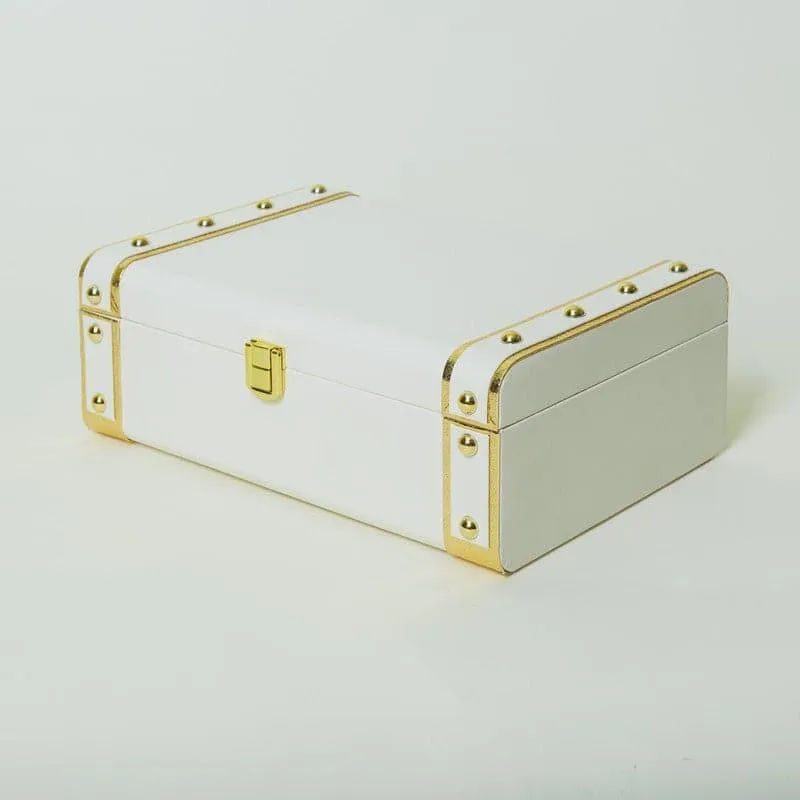 Closed white gift box with gold-toned trim
