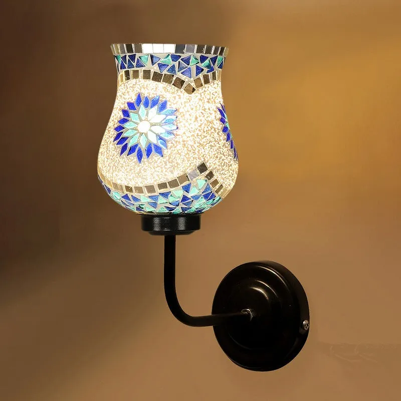 Close-up of lit mosaic glass wall lamp with blue and silver detailing