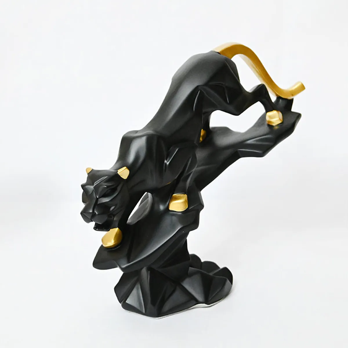 Studio view of a black and gold crouching panther showpiece on a white background