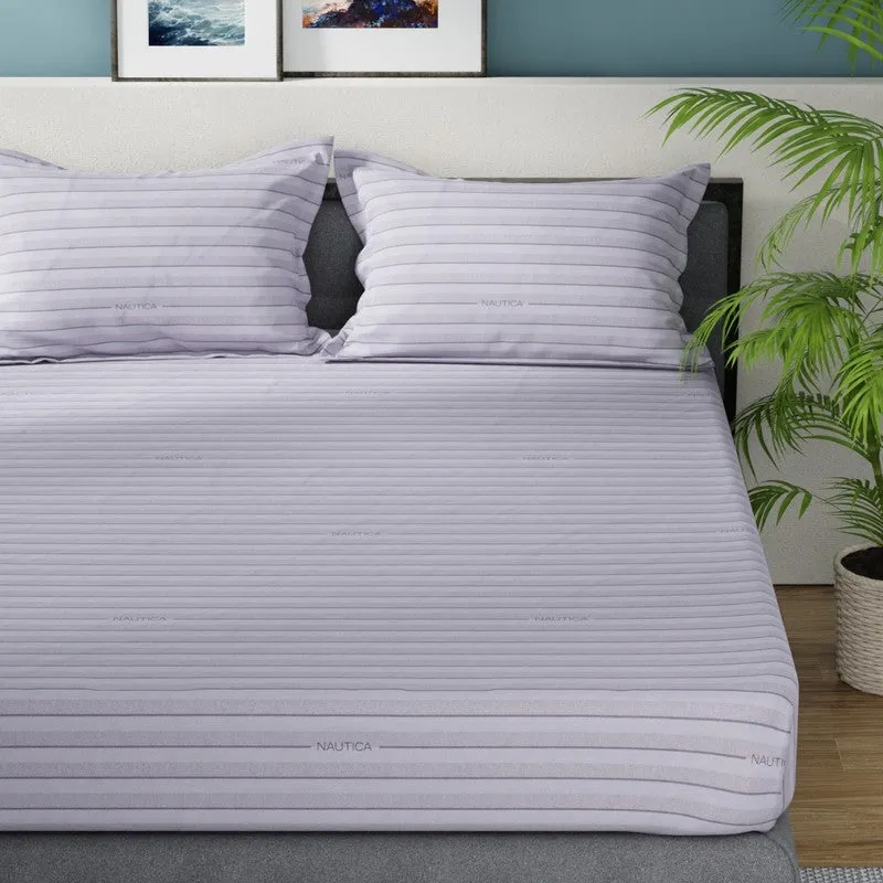 Blue striped flat bedsheet spread on a bed with matching pillows
