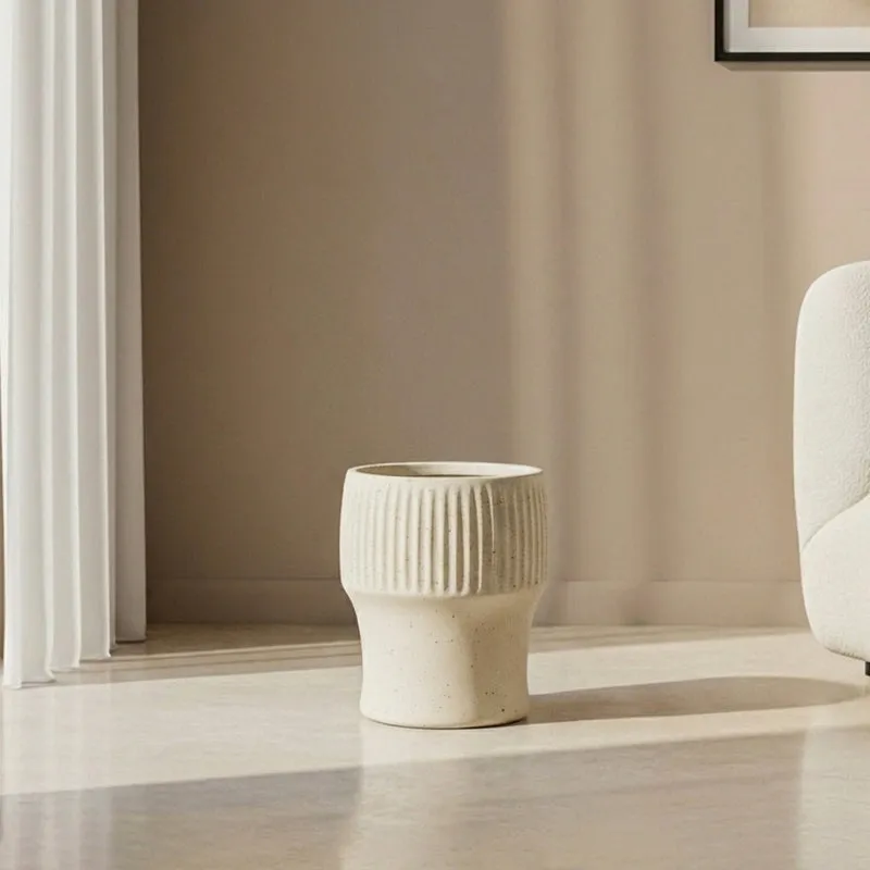 White ribbed planter shown empty on a light floor