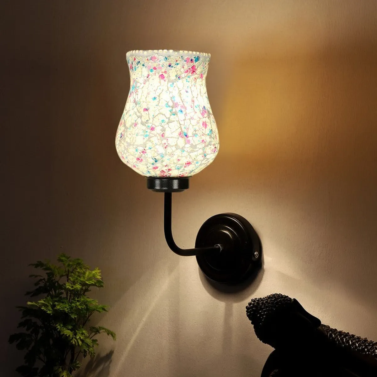 Lit mosaic glass wall lamp casting warm light on the wall