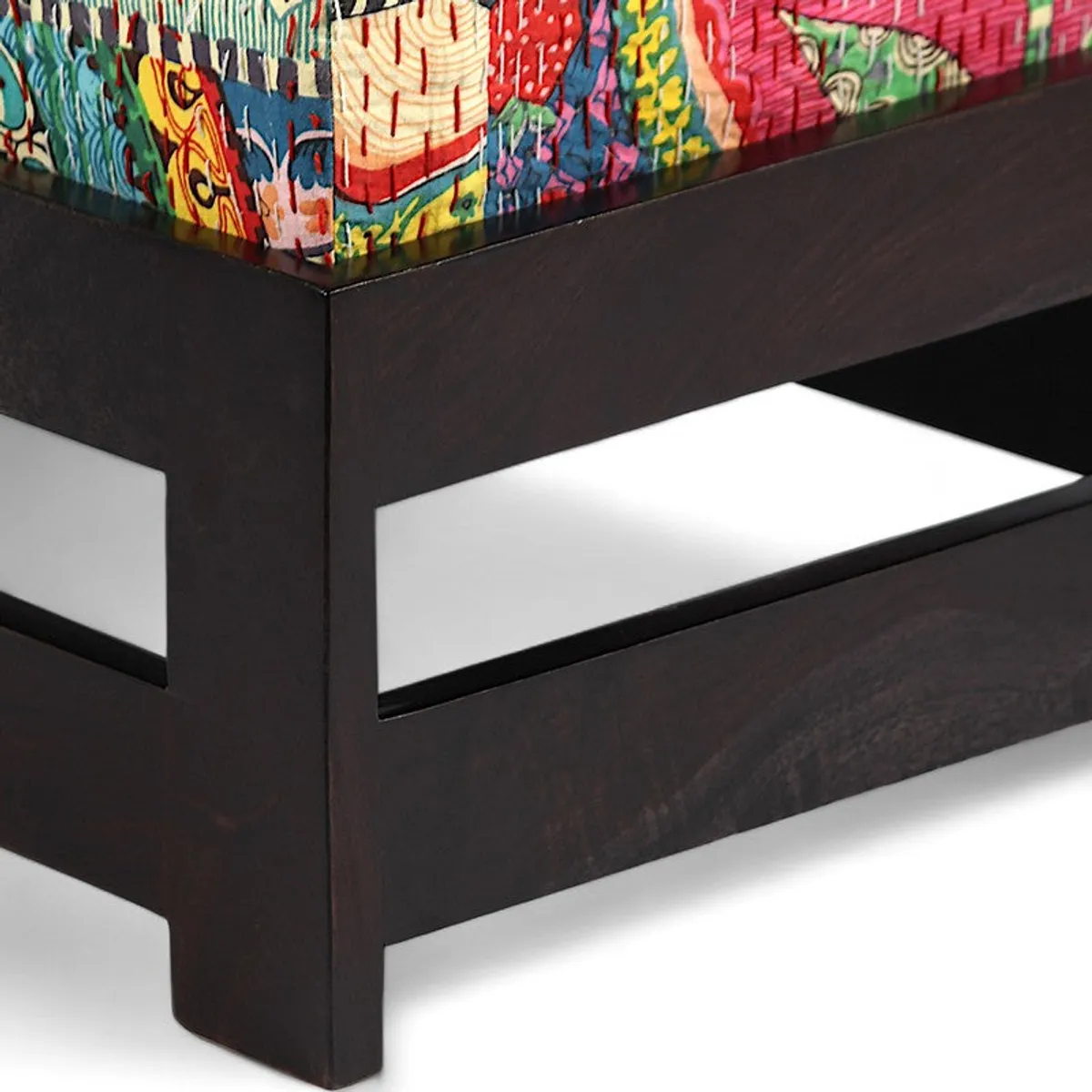 Close-up of dark wood frame and bright patterned cushion edge